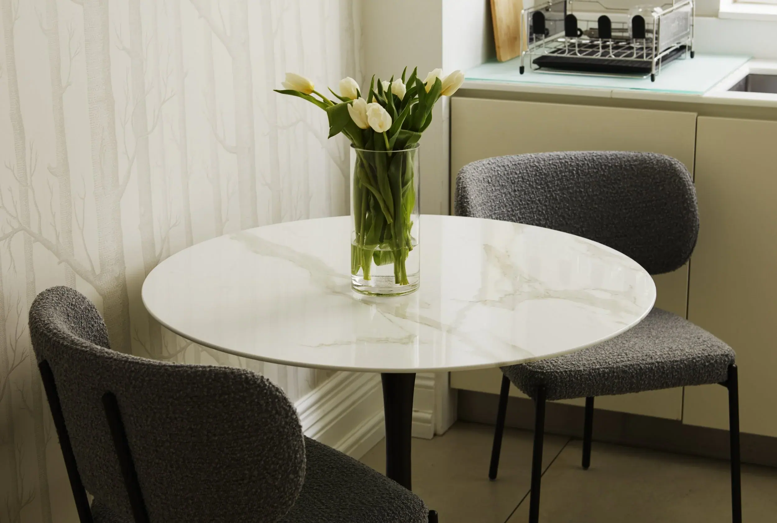 Marble dining table and boucle chairs in a Hampstead apartment by Studio Schubert