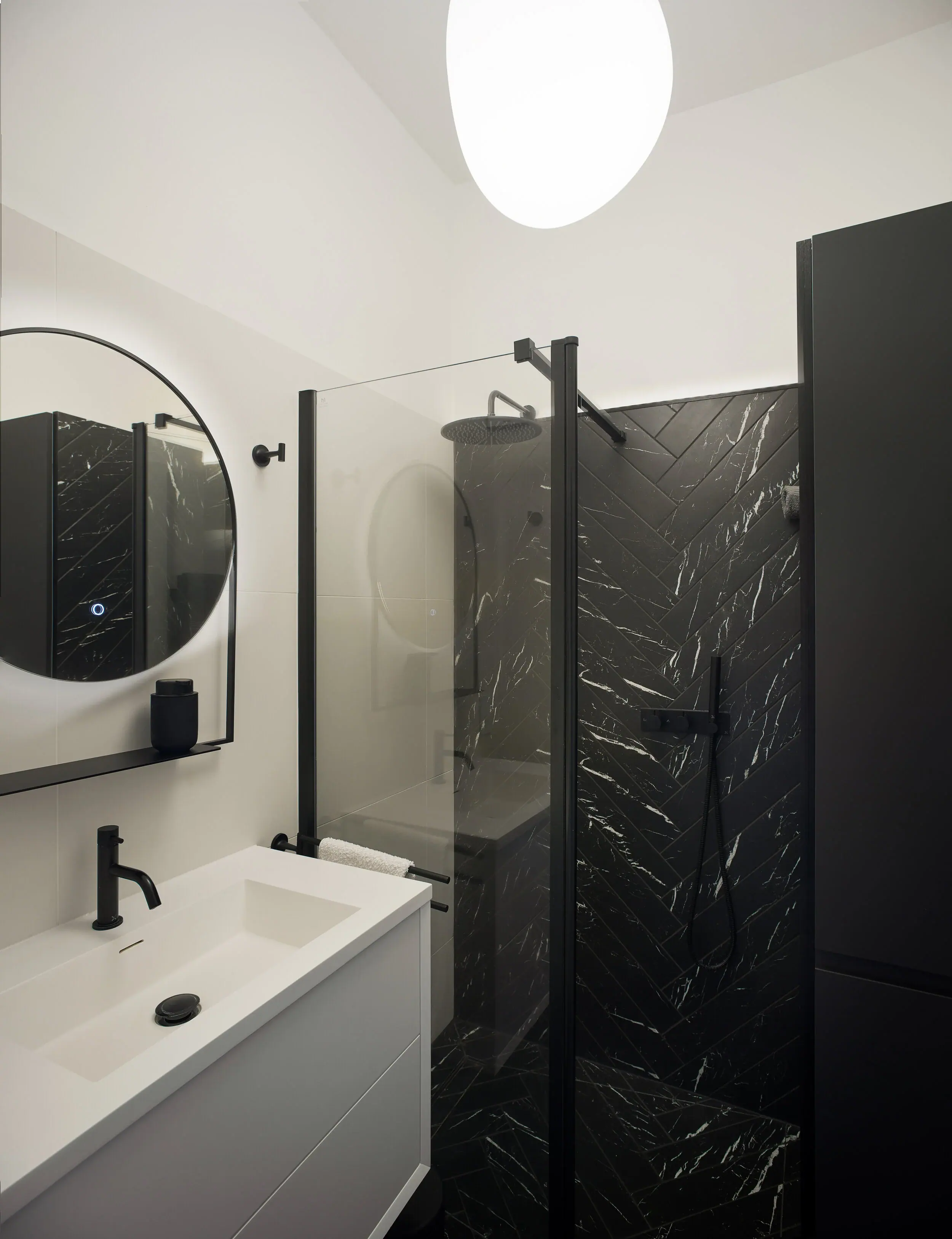 The small bathroom was completely reconfigured, we can now get a large basin with storage and walk-in shower with (lighting elevating) feature wall.